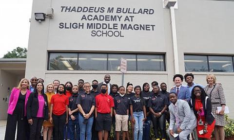 Students, faculty and Thaddeus Bullard pose in front of Thaddeus M Bullard Academy At Sligh Middle Magnet School