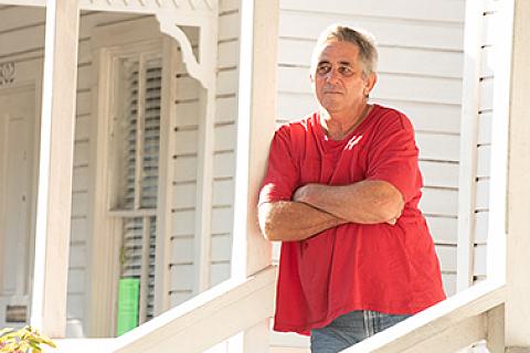 Man Standing on House Porch